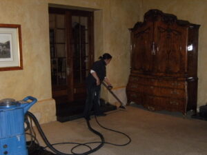 Image showing a System Restoration Technologies employee vacuuming a room, adding finishing touches.